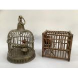 A metal bird cage with carrying handle and feathered bird on a swing together with a Chinese style