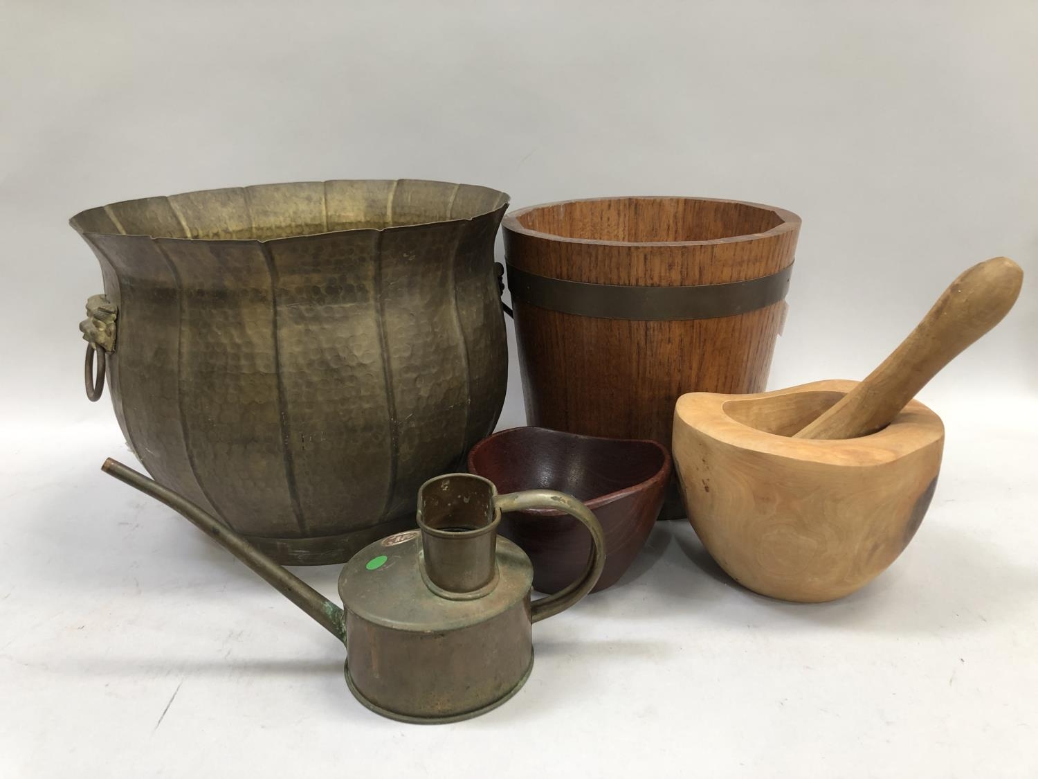 A banded ice bucket, a bear carved pestle and mortar, another wooden bowl and a brass moulded coal