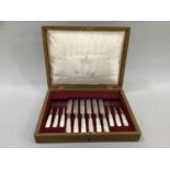 A Victorian oak canteen of six mother-of-pearl handled silver plated dessert knives and forks
