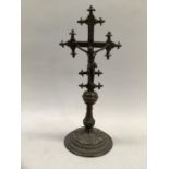 A bronze crucifix, 19th century, on a leaf cast domed base, 24cm high