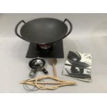 A Le Creuset wok and stand with firelighter and accessories together with a Le Creuset circular