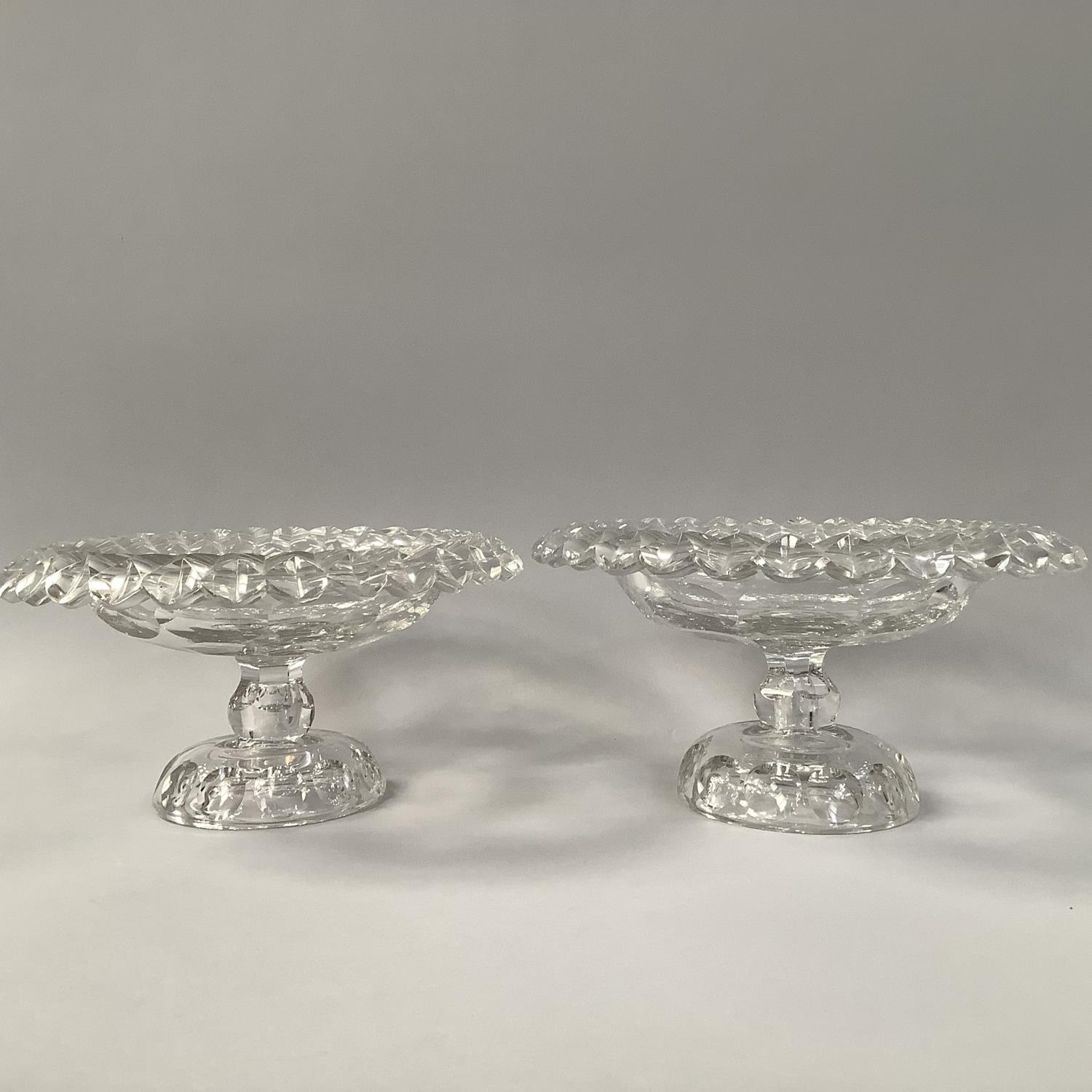 A PAIR OF MID 18TH CENTURY IRISH GLASS PEDESTAL BOWLS, circular with petal edges and disc cut