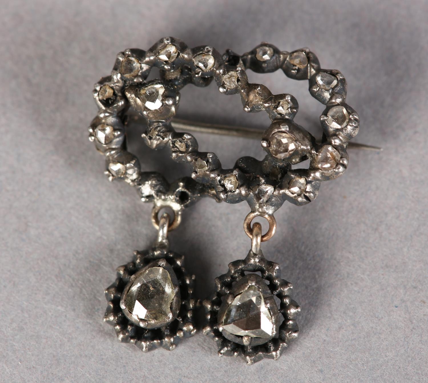 A BOW BROOCH SET WITH 17TH CENTURY ROSE CUT DIAMONDS in closed silver cut down setting including two