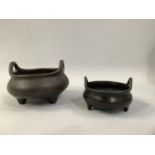 A 19TH CENTURY CHINESE BRONZE CENSER, circular with loop handles, on three feet, cast seal mark,