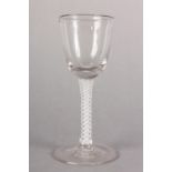 AN 18TH CENTURY WINE GLASS, the ogee bowl on a lace and opaque twist stem, on a conical foot, c.1770