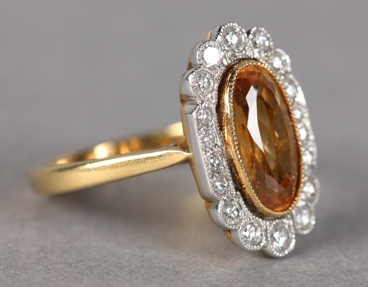 A TOPAZ AND DIAMOND CLUSTER RING in 18ct yellow and white gold, collet set to the centre with an - Image 2 of 3