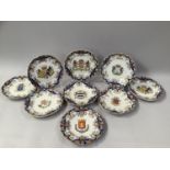NINE ROUEN FAIENCE ARMORIAL PLATES, circular with bracketed rims, painted in typical colours, with