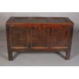 AN EARLY 18TH CENTURY OAK KIST having a triple indented top above a frieze carved with the