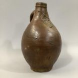 A 17TH CENTURY RHENISH BELLARMINE, stoneware flagon, ovoid with face mask to neck and loop handle,