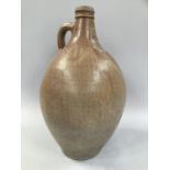 A 17TH CENTURY RHENISH BELLARMINE stoneware flagon with face mask to neck and loop handle, 45cm high