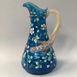 A LATE 19TH CENTURY ART GLASS JUG, the deep turquoise body enamelled with sprays of blossom in