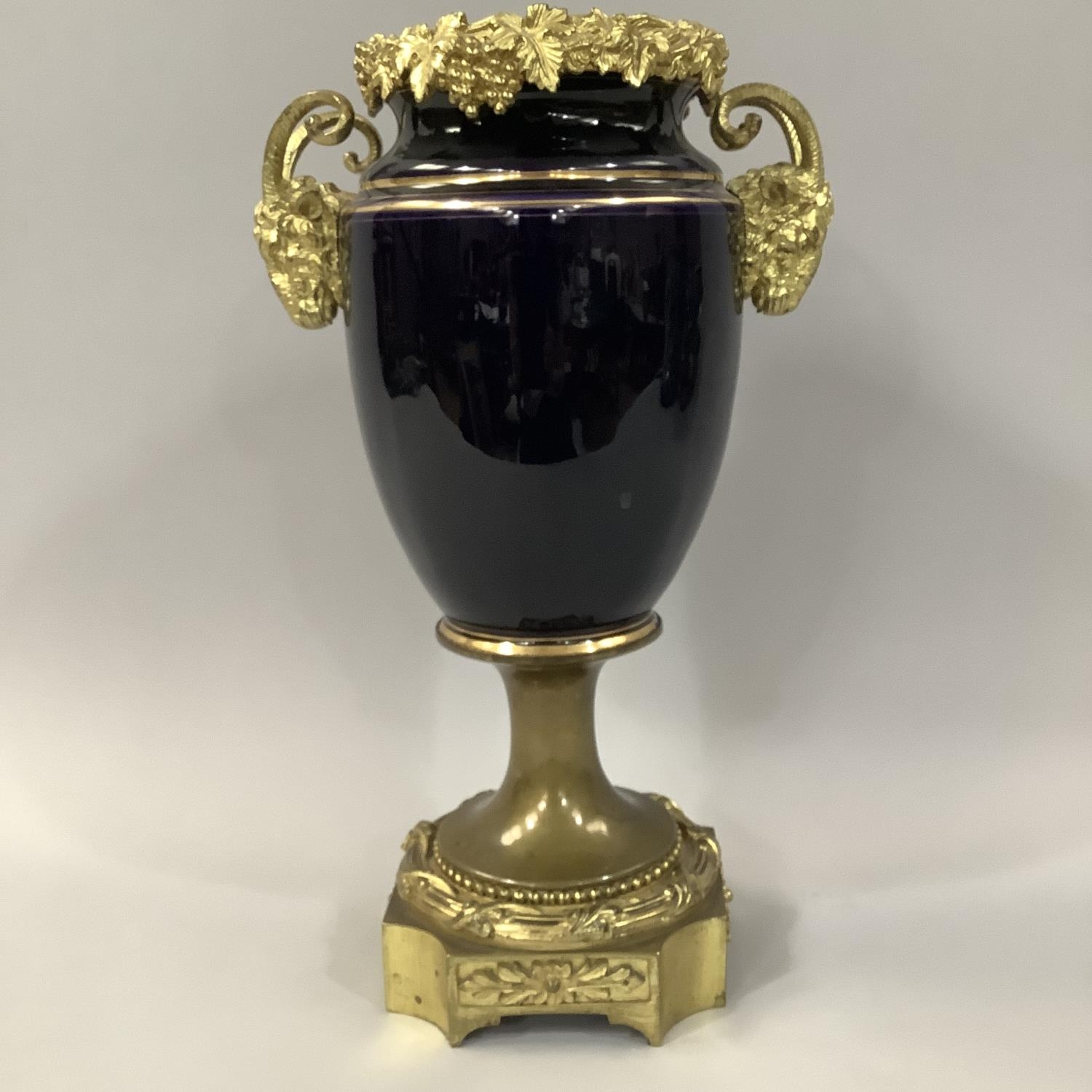 19TH CENTURY FRENCH PORCELAIN AND GILT METAL MOUNTED URN WITH GRAPEVINE RIM, the gros bleu ovoid