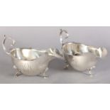 A PAIR OF EDWARD VII SILVER SAUCE BOATS each with C scroll handles, incised rim on three pad feet,