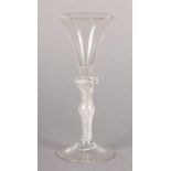 A MID 18TH CENTURY WINE GLASS, the trumpet bowl on a double knopped multi air twist stem with