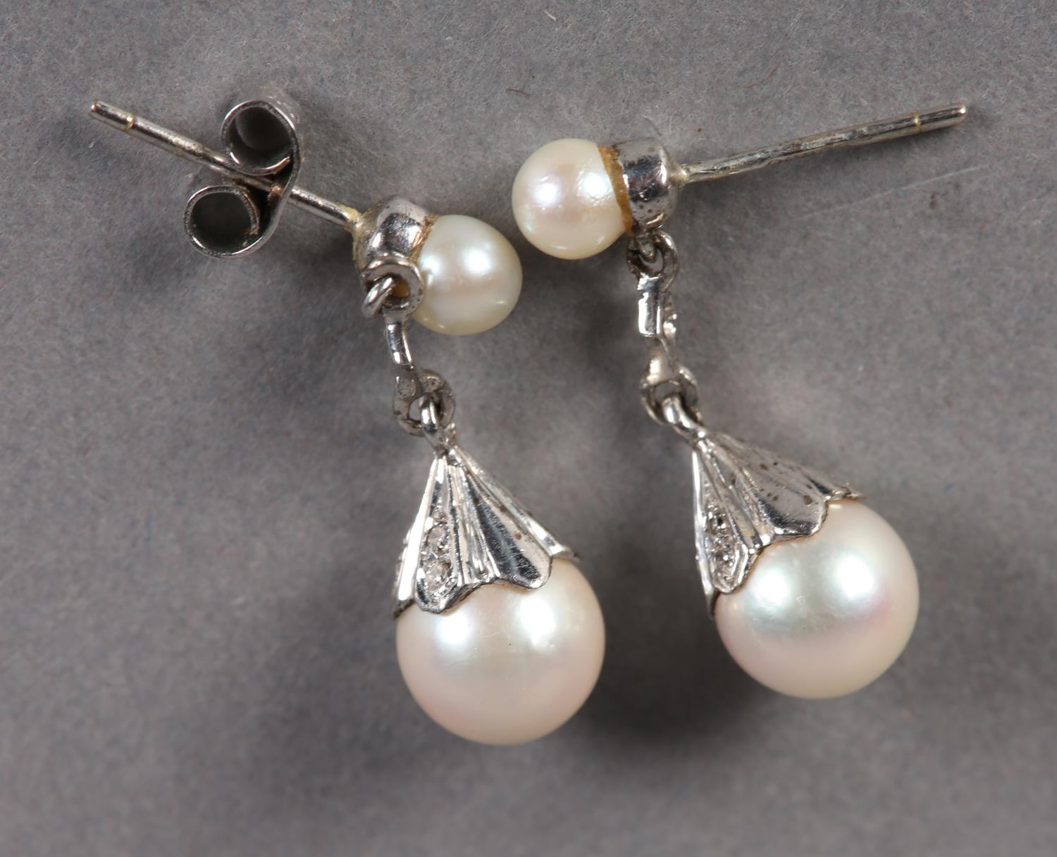 A PAIR CULTURED PEARL AND DIAMOND EARRINGS in 9ct white gold, each 7.5mm pearl in a crenulated cup - Image 2 of 2