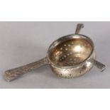 A SILVER TEA STRAINER BY LIBERTY & CO, in Celtic revival style, number 3187, hallmarked Birmingham