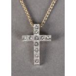 A DIAMOND SET CROSS in 18ct white gold, the princess cut stones channel set, hung from a fine 18ct