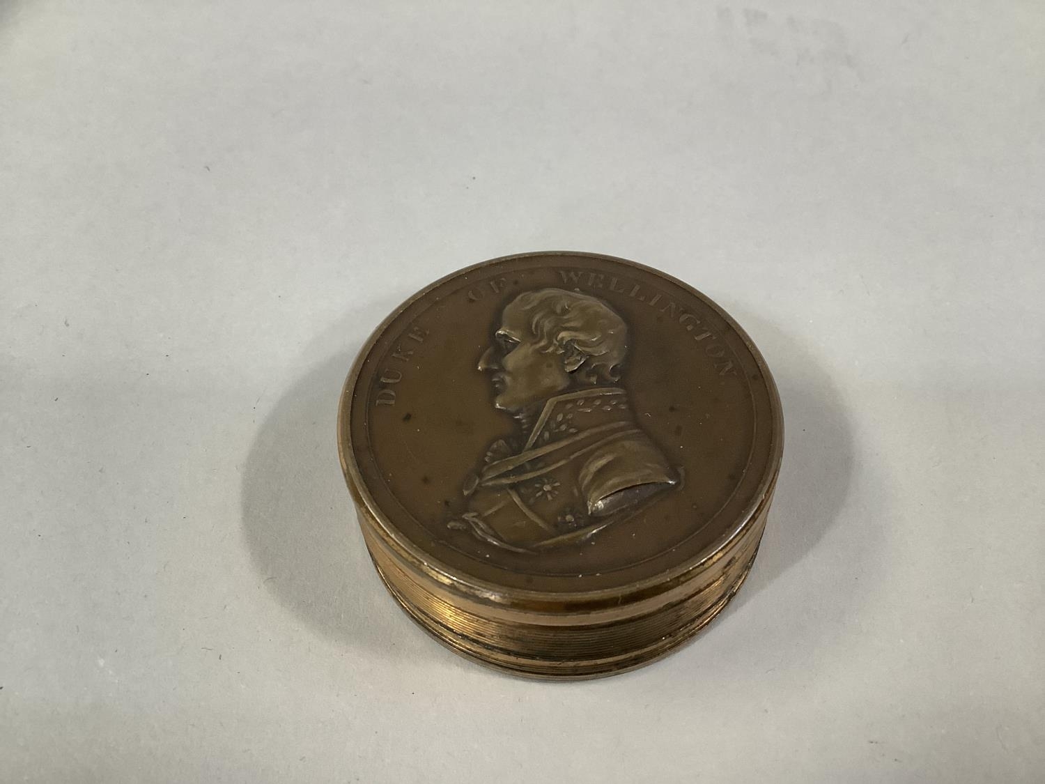 19th CENTURY DUKE OF WELLINGTON BRONZE BOX MEDAL containing twelve circular pieces of paper with