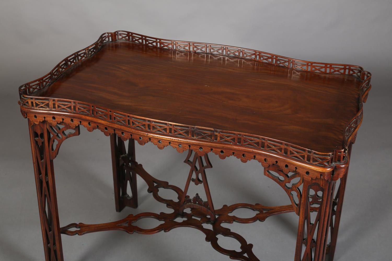 A GEORGE III MAHOGANY TEA TABLE of rectangular serpentine outline with fretwork gallery apron, angle - Image 2 of 6