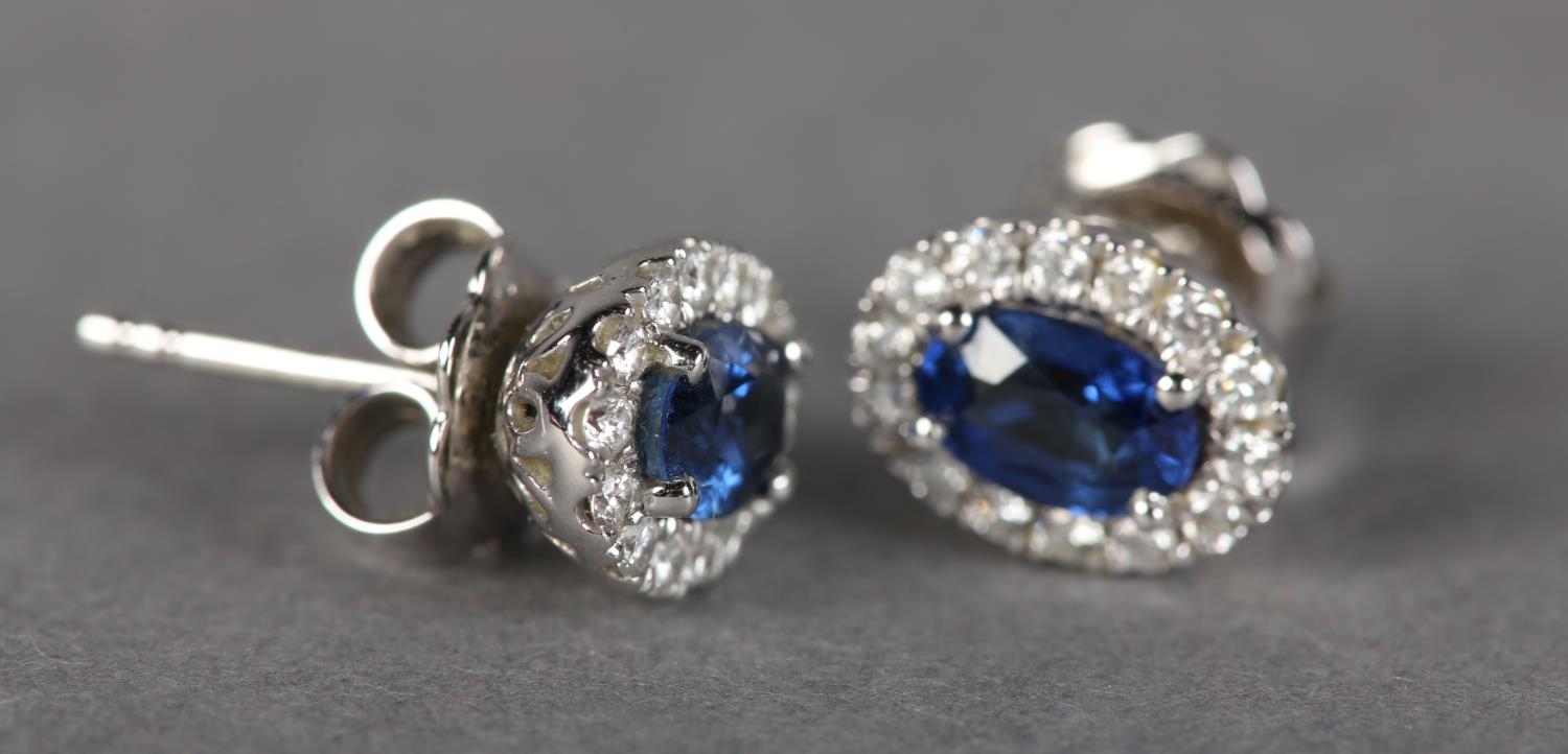 A PAIR OF SAPPHIRE AND DIAMOND CLUSTER EARRINGS in 18ct white gold, each claw set to the centre with - Image 2 of 3