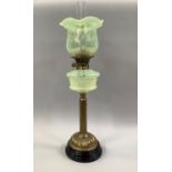 A VICTORIAN BRASS OIL LAMP, having a vaseline glass reservoir and writhen shade with folded rim