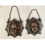 A PAIR OF 19TH CENTURY FRENCH COPPER ALLOY WALL MASKS, cast in relief with a child's face smiling