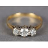 A THREE STONE DIAMOND RING in 18ct yellow and white gold, the graduated round brilliant cut stones