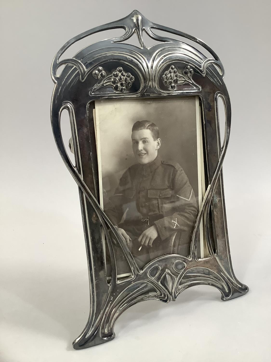 AN ART NOUVEAU SILVER PLATED PHOTOGRAPH FRAME BY WMF, of arched rectangular outline, cast with plant