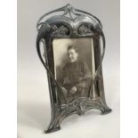 AN ART NOUVEAU SILVER PLATED PHOTOGRAPH FRAME BY WMF, of arched rectangular outline, cast with plant