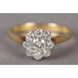A DIAMOND CLUSTER RING in 18ct yellow and white gold, the brilliant cut stones claw set within a