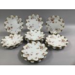 A SET OF SIXTEEN LIMOGES HAVILAND DESSERT PLATES with moulded edges, gilt pooling and painted with