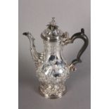 A GEORGE III COFFEE POT, London 1769, by Abraham Portal, baluster form, foliate chased, ebonised