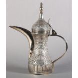 AN EARLY TO MID 20TH CENTURY SAUDI ARABIAN SILVER DALLAH all over foliate scroll with emblem and
