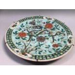 A Chinese polychrome charger, with central decoration of dragon in flowering foliage, on turquoise