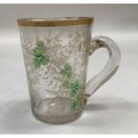 A Victorian glass handled mug, the body enamelled with white and green floral sprays and gilt,