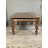 A large pine farmhouse kitchen table on baluster legs and ceramic casters, with one drawer, 116cm by