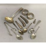 A collection of silver cutlery inc. two napkin rings, sugar tongs, filled handles and part of a