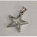 A diamond star pendant in 18ct white gold, cut stone claw set within the open five pointed star.
