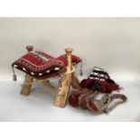 Carved camel saddle with hide rope and kilim cushion 54cm long, together with camel flatweave end