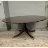 A reproduction mahogany circular dining table by Millwood cabinet makers on tripod splayed legs with