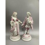 Pair of continental porcelain figures of a man and woman in contemporary dress on plinth bases