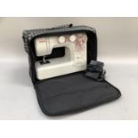 A Janome HC1200 sewing machine with lead, instructions and carry bag.