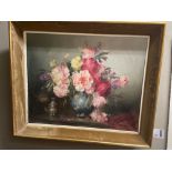 Still life painting of roses in a vase with silver castor on a table, indistinctly signed in gilt