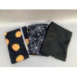 A length of Jersey-style fabric printed with Halloween pumpkins on a black ground, similar fabric