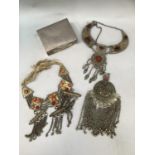 Three early 20th Century Middle Eastern necklaces all in base metal, variously set with a red and