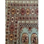 A Bokara rug in pale blue grey, ivory and camel, the field having three rows of elephant foot