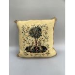 Yellow tapestry cushion depicting lion and unicorn under tree with scattered foliage, edged with