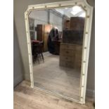 A large cream and gilt over mantel mirror, rectangular with cut away corners, 169cm by 122cm