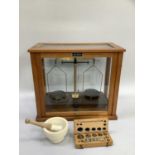 A set of cased laboratory scales marked Griffin and George ltd. London, a set of weights in wooden