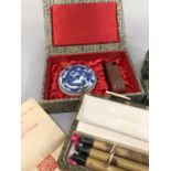 Eight boxed sets of Chinese lacquered chopsticks, another box containing a blue and white ink pot